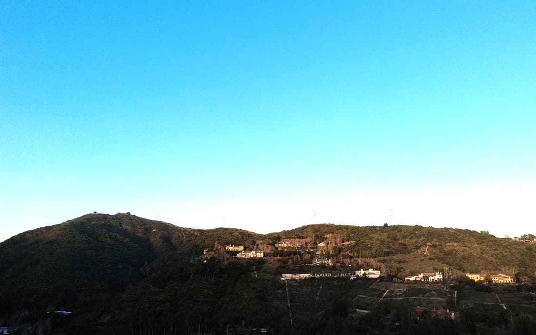 A long ridge of developed hillside at dusk, distance and access from a fire front