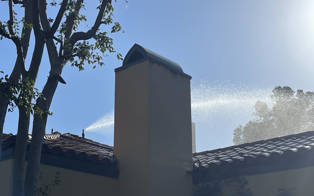 A tile roofline against open sky, the surface embers land on first