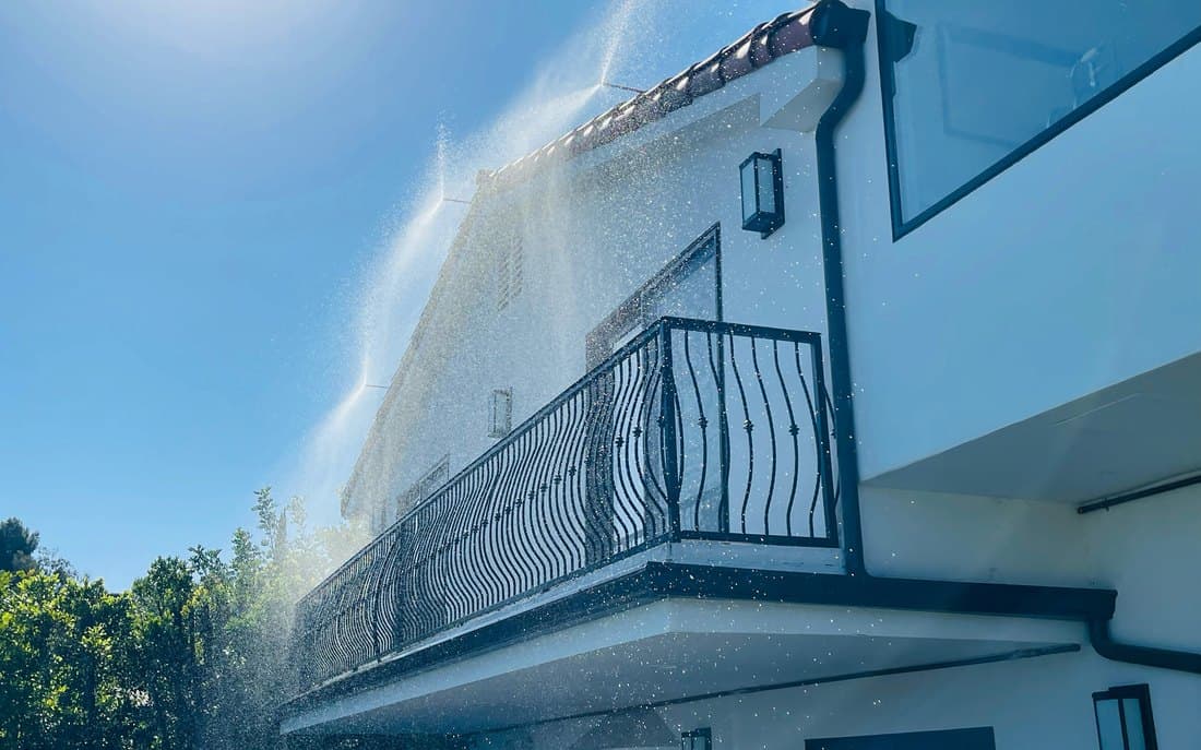 Eave and wall detail of a house with the system wetting it down