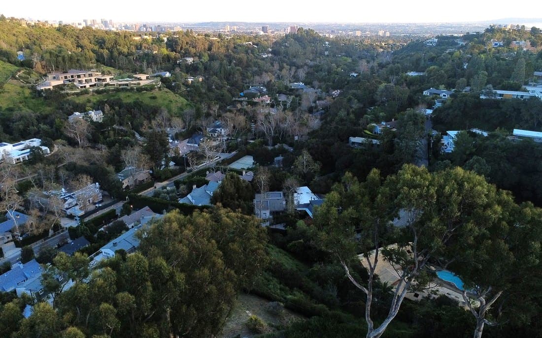 Dense hillside housing where properties sit close together among trees
