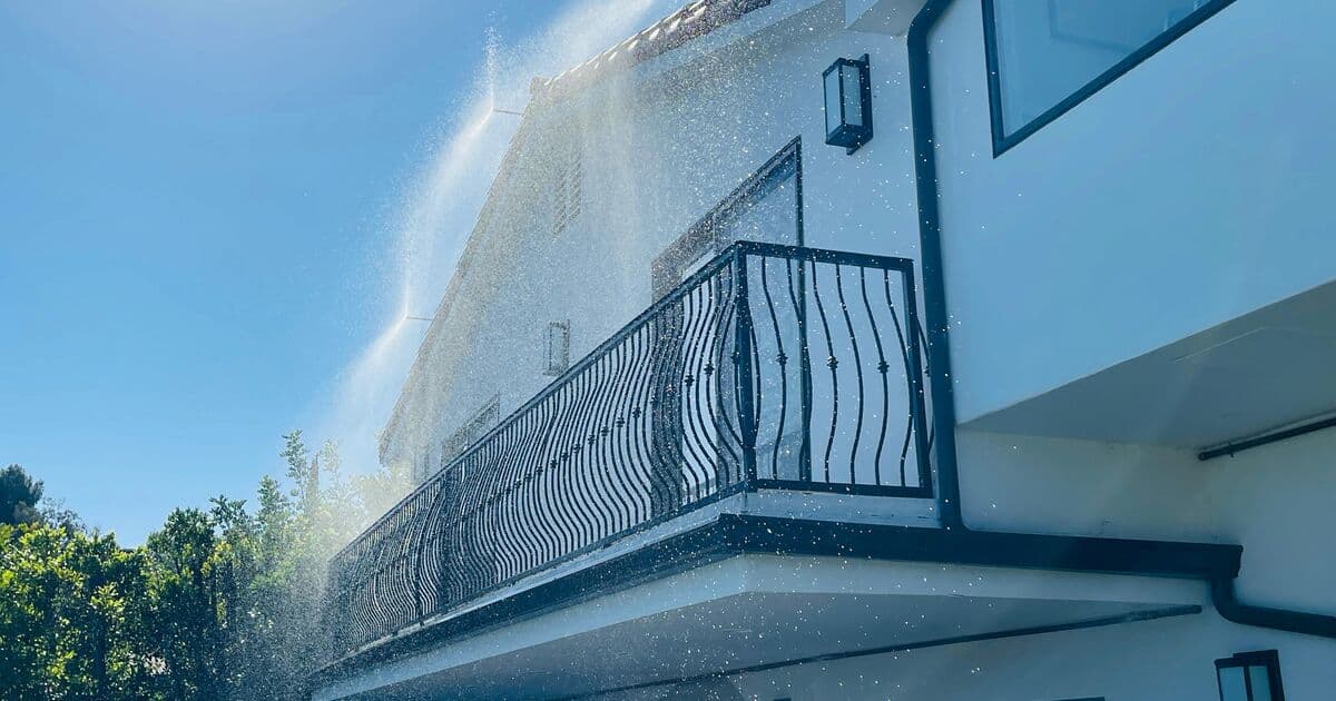 A FireShield system spraying the eaves of a two-story home