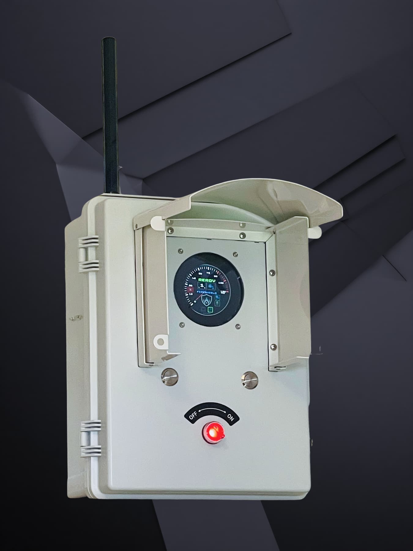 The FireShield Defense Core: a weatherproof enclosure with an integrated sun and rain shield, external antenna, illuminated gauge display reading READY, and a red OFF/ON selector glowing beneath it.