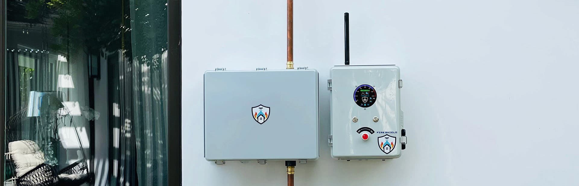 The FireShield controller installed on an exterior wall, showing the weatherproof enclosure and status display